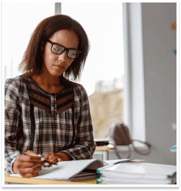 woman with glasses takes notes