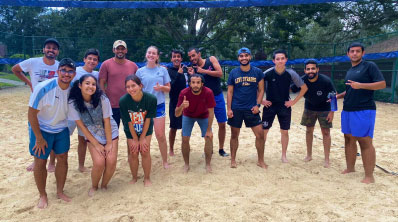 large group poses for photo on beach