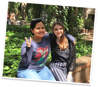Two friends outdoors making peace sign